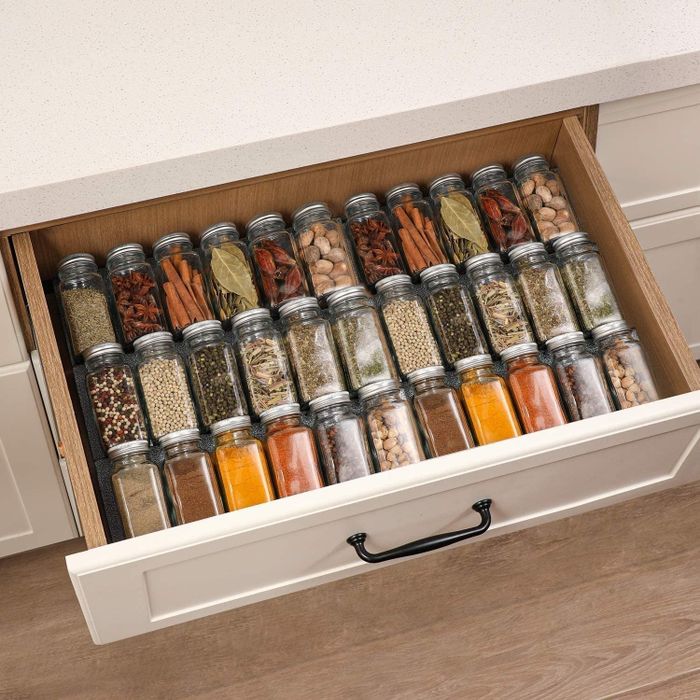 The spice jars neatly arranged inside a drawer
