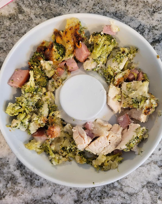 A white ceramic bowl filled with chicken and vegetables