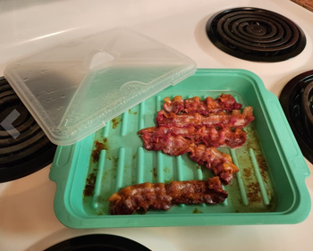The bacon, now fully cooked and crispy, inside the container.