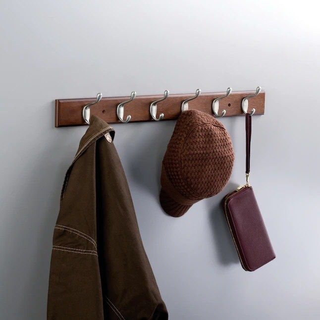 A bark and satin nickel wall hook displaying a hat, purse, and jacket
