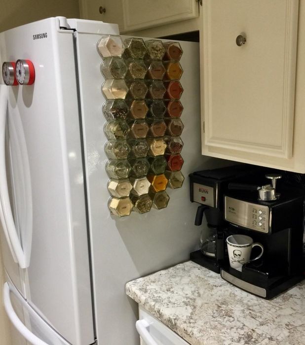 A reviewer’s photo showing several glass spice jars magnetically attached to the side of a fridge