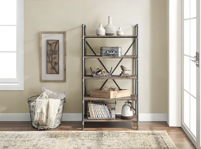 A chic shelving unit displaying decorative items like vases, framed art, a blanket-filled basket, and rustic accents, ideal for both home decor and organization