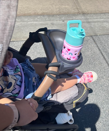 A child sitting in a stroller with a snack tray attached.
