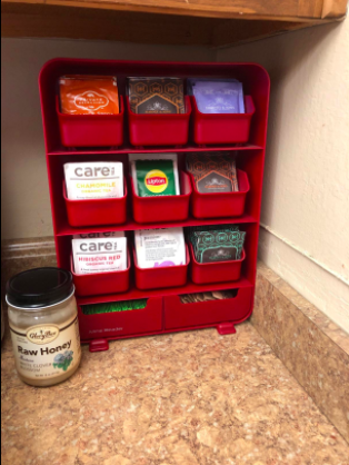 A vertical organizer sitting on the counter, each compartment holding a different kind of tea bag