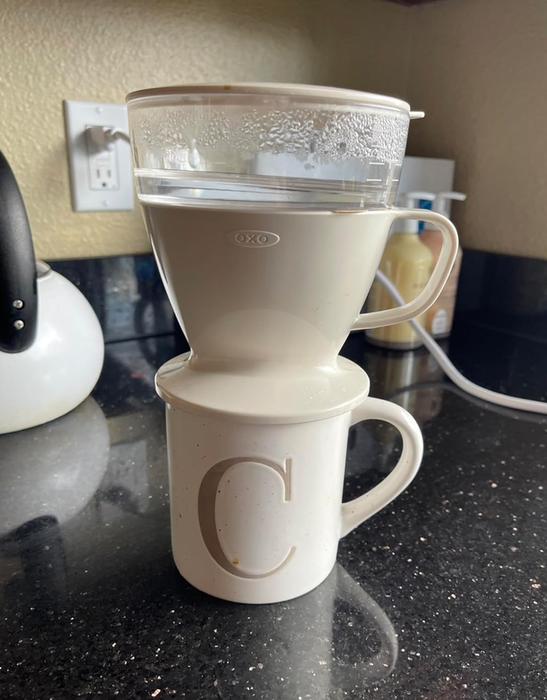 An OXO coffee dripper placed on top of a mug, sitting on a kitchen counter
