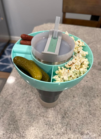 A blue version of the bowl, holding popcorn, pickles, and meat