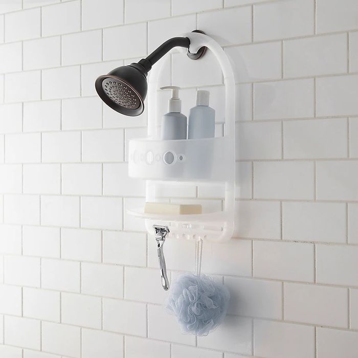 A satin nickel shower caddy hanging elegantly by the shower head