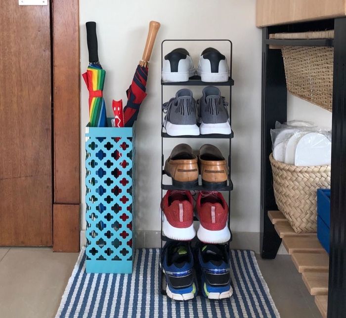 A reviewer showcases their shoe rack placed neatly in the entryway, helping to save space and keep shoes organized.