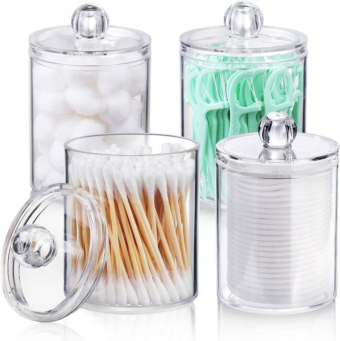 Four clear acrylic jars neatly organizing cotton balls, floss picks, cotton swabs, and cotton rounds