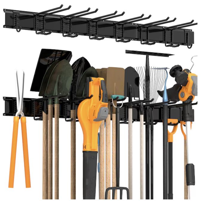 Wall-mounted storage rack holding various garden tools, including shovels, rakes, shears, a hedge trimmer, and a leaf blower