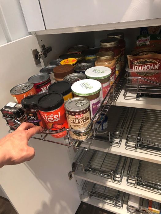 A reviewer demonstrates the ease of use by pulling out a sliding shelf from their cabinet.