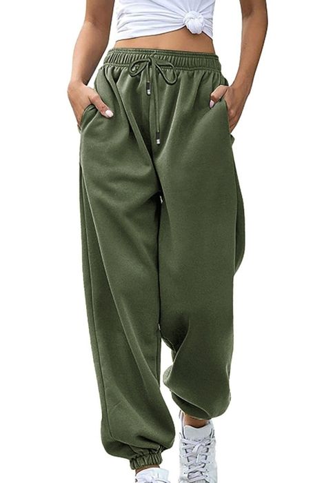 A person is seen wearing a pair of relaxed-fit green joggers and sneakers, exuding a casual vibe.
