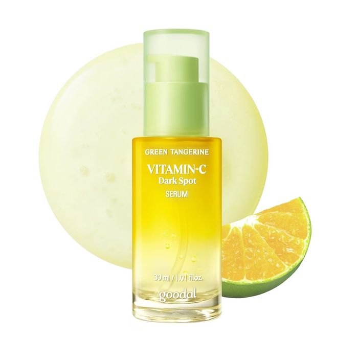 A bottle of Goodal Green Tangerine Vitamin C Dark Spot Serum with a slice of citrus fruit placed next to it.