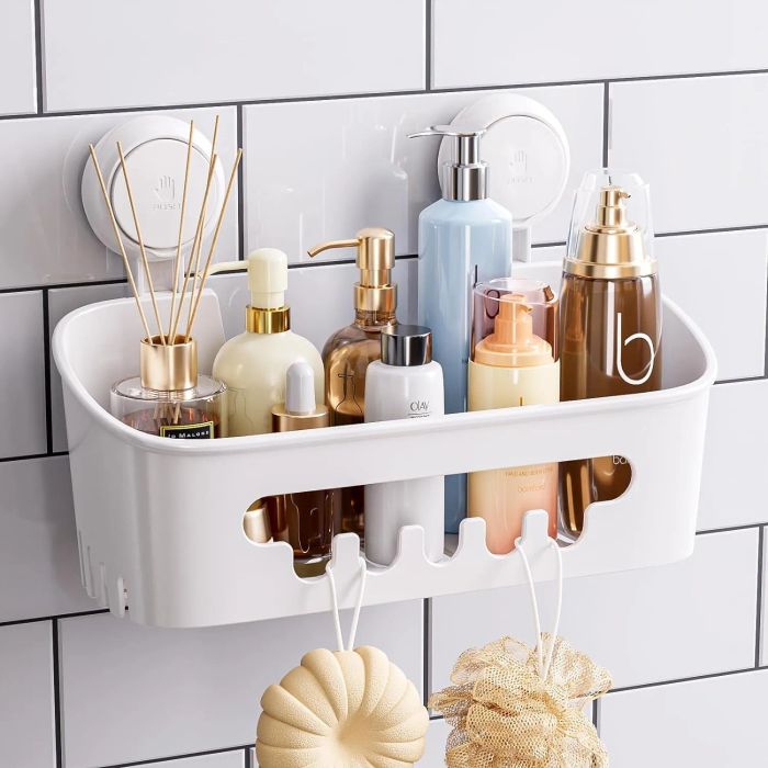 Shower caddy holding various bath and skincare products like lotions, soap, and fragrance sticks, mounted on a tiled wall, with a loofah hanging underneath