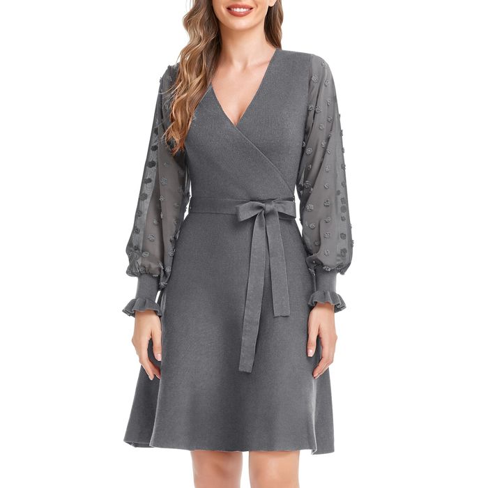 A model is wearing a cozy grey sweater dress that’s artfully wrapped to create a flattering silhouette.