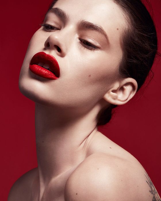 Another model with a lighter complexion applying the lip stain.
