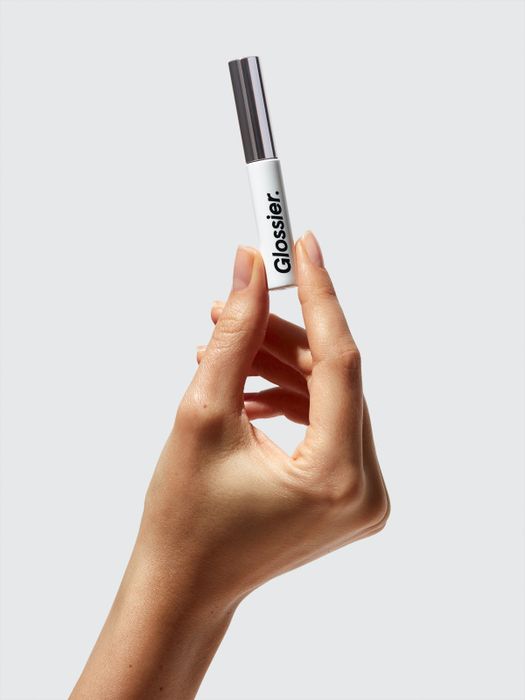 Hand holding the Boy Brow tube.