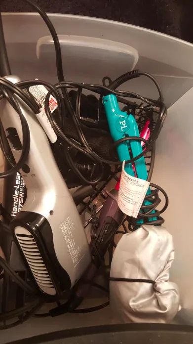 A before photo from the reviewer showing their hair tools in one chaotic pile.