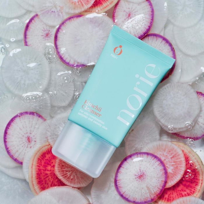 A bottle of cleanser placed atop sliced radishes