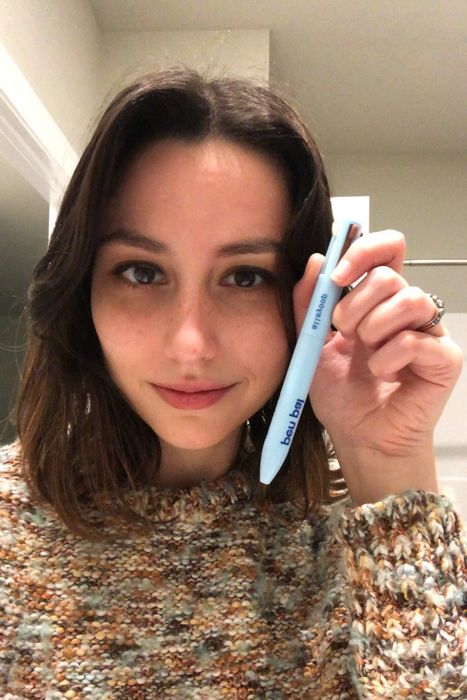 Editor holding the multi-functional 4-in-1 makeup pen.