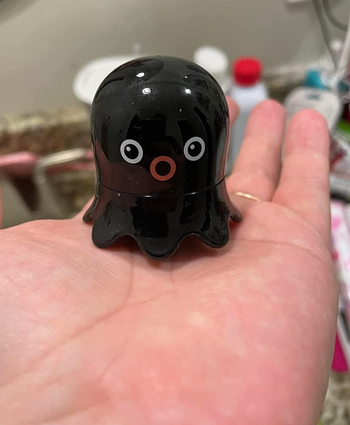 Reviewer holding a small black octopus-shaped tool.