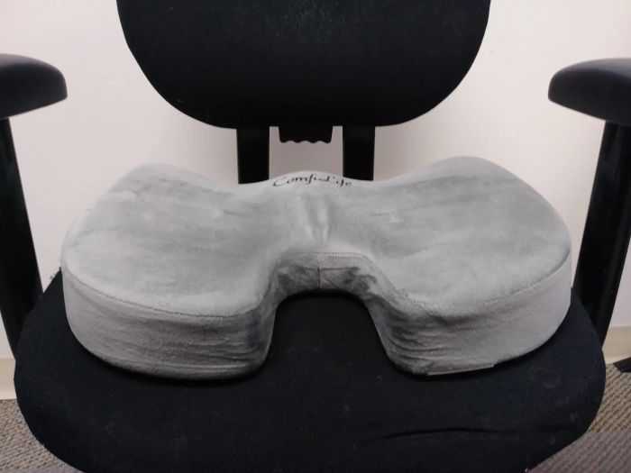 A reviewer's swivel office chair with a memory foam cushion placed on it for extra comfort.