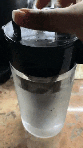 A reviewer showing how to load the coffee maker and give it a shake