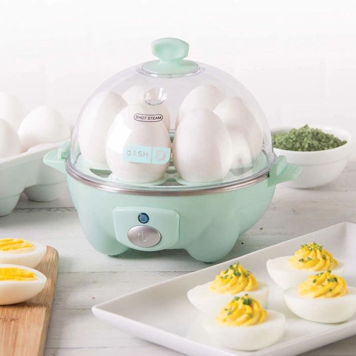 A transparent dome lid of the egg cooker revealing six eggs as they cook inside.