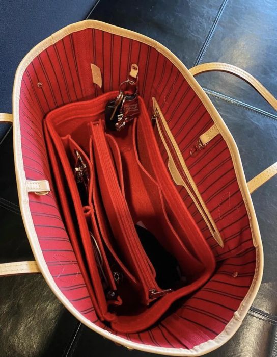 A red felt insert placed at the base of a tote-style handbag.