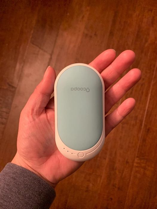A reviewer holding the hand warmer