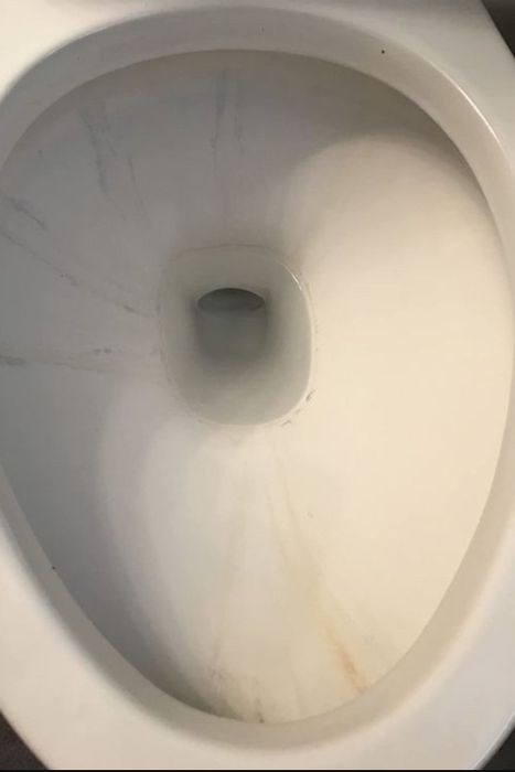 A before image showing a toilet stained and grimy