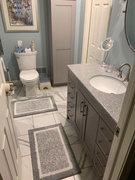 Two of the soft bath rugs laid out on the bathroom floor.