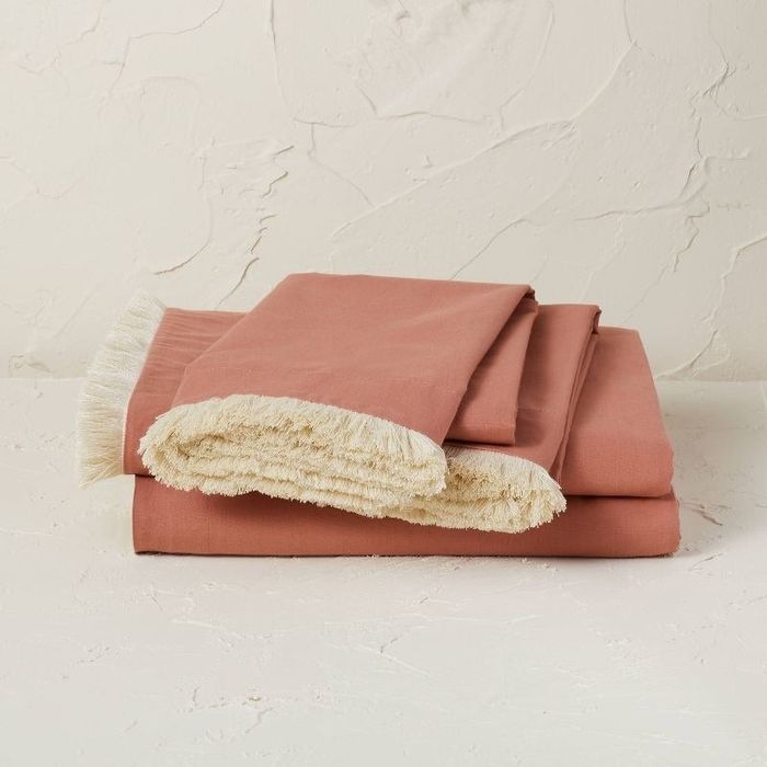 The burnt orange sheets adorned with tan trim.