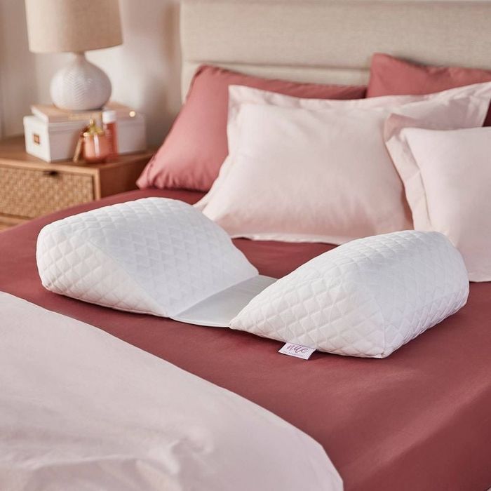 An image of the white pillow on pink sheets on the bed.