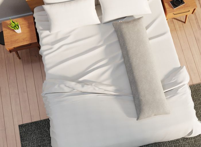Image of the ivory pillow resting on a bed