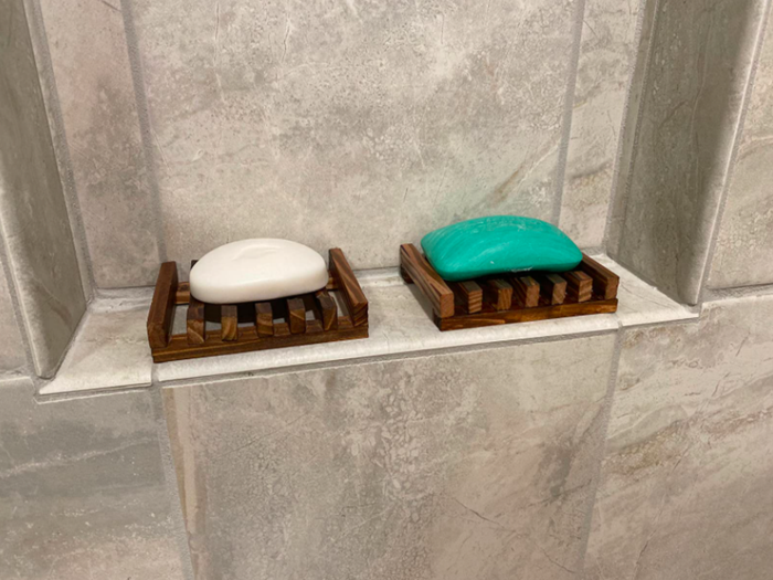 The reviewer shares two wooden soap dishes, designed with spaces to let the soap drip.