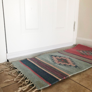 A reviewer’s photo of a white door with a barely noticeable draft stopper along the bottom edge