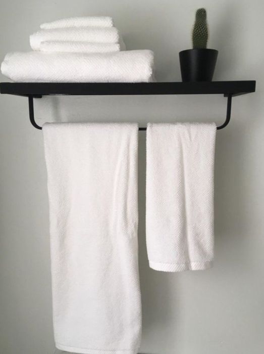 White towels neatly hanging on a shelf, adding a clean touch.