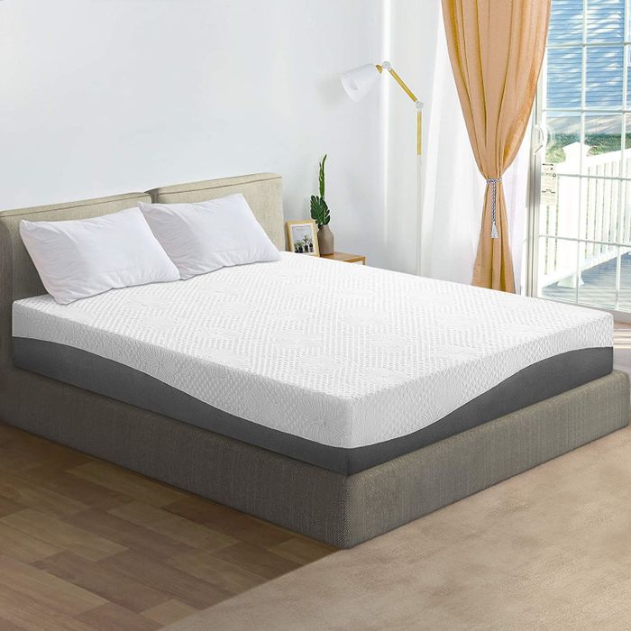 A white and gray mattress placed on a bed.