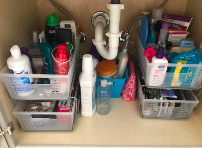 A photo showing the same under-sink area now neatly organized with the baskets.