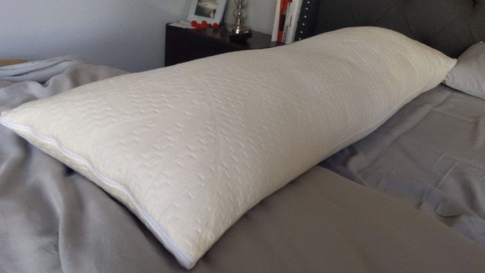 Reviewer photo showing the white pillow resting on a bed