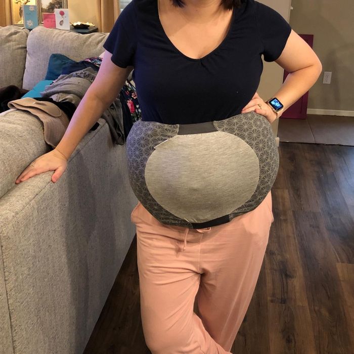 The reviewer is showcasing the gray pillow belt.