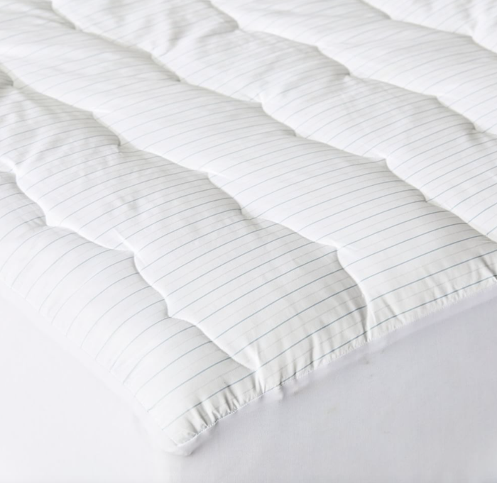 A close-up view of the mattress topper with subtle stripes.
