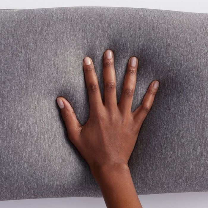 Model’s hand resting on the pregnancy pillow