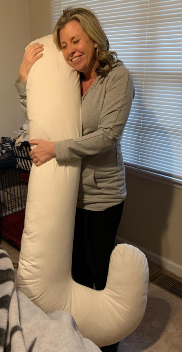 Image of a reviewer holding the white Snoogle pregnancy pillow.