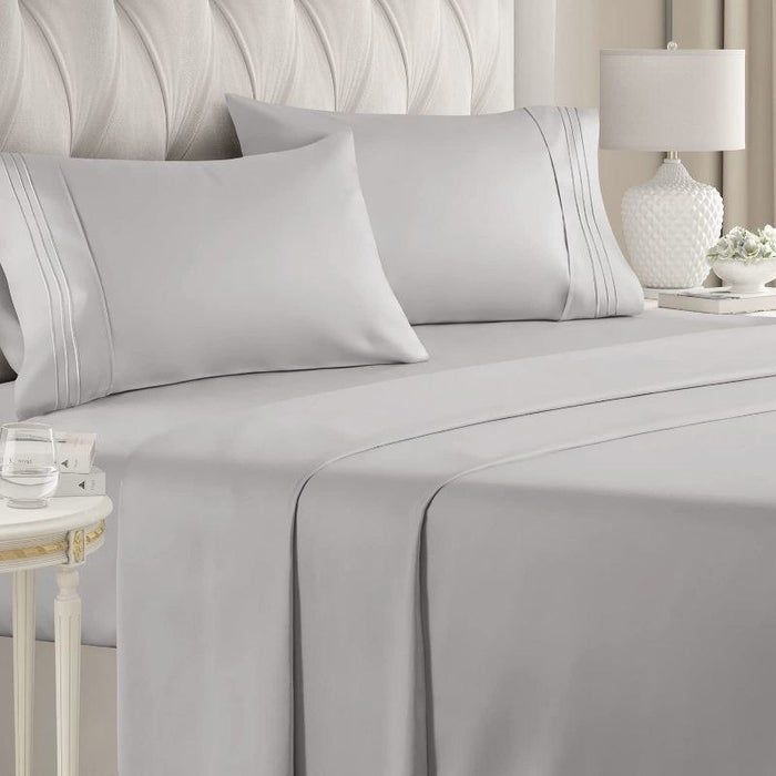 gray sheets with piping details on a neatly made bed