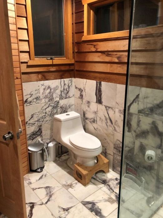 The bamboo Squatty Potty positioned in front of a toilet