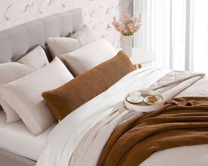 Image of a brown body pillow resting on a bed