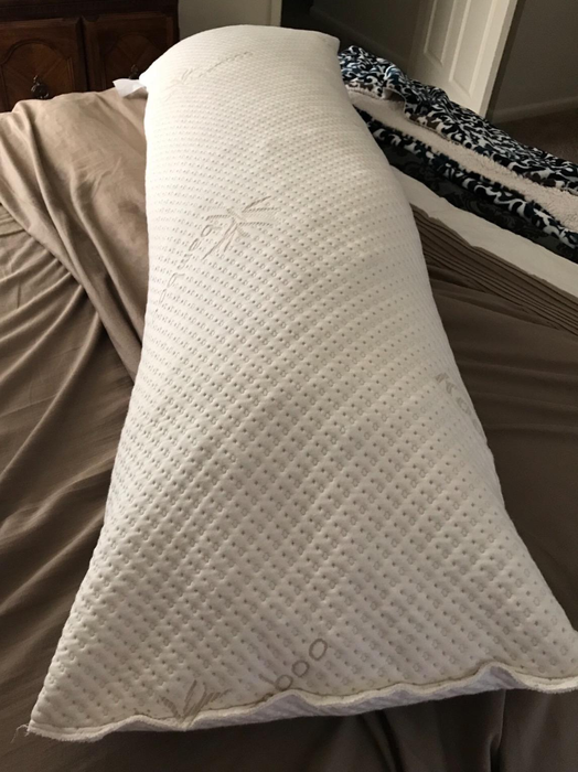 Image showing the white body pillow on brown sheets.