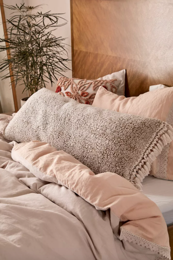 Photo of the beige body pillow placed on a bed